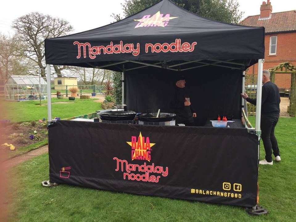 A black Gala Shade Pop-up Gazebo with a custom printed canopy and half wall for a street food vendor